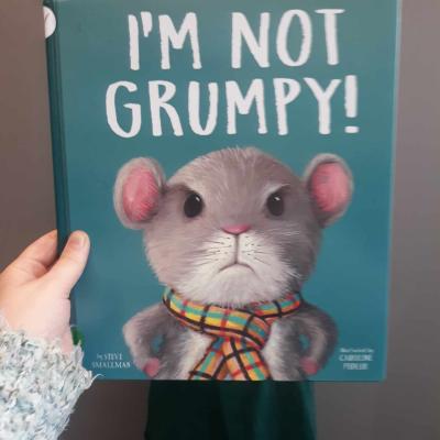 Image of Melissa posing with book cover, "I'm Not Grumpy"