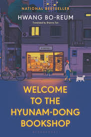 Book cover showing a dark street looking into a brightly lit bookshop.