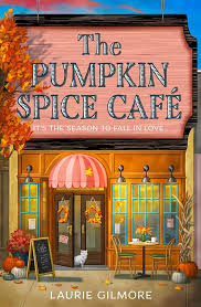 Book cover showing a café with fall décor and a white cat exiting the front door.