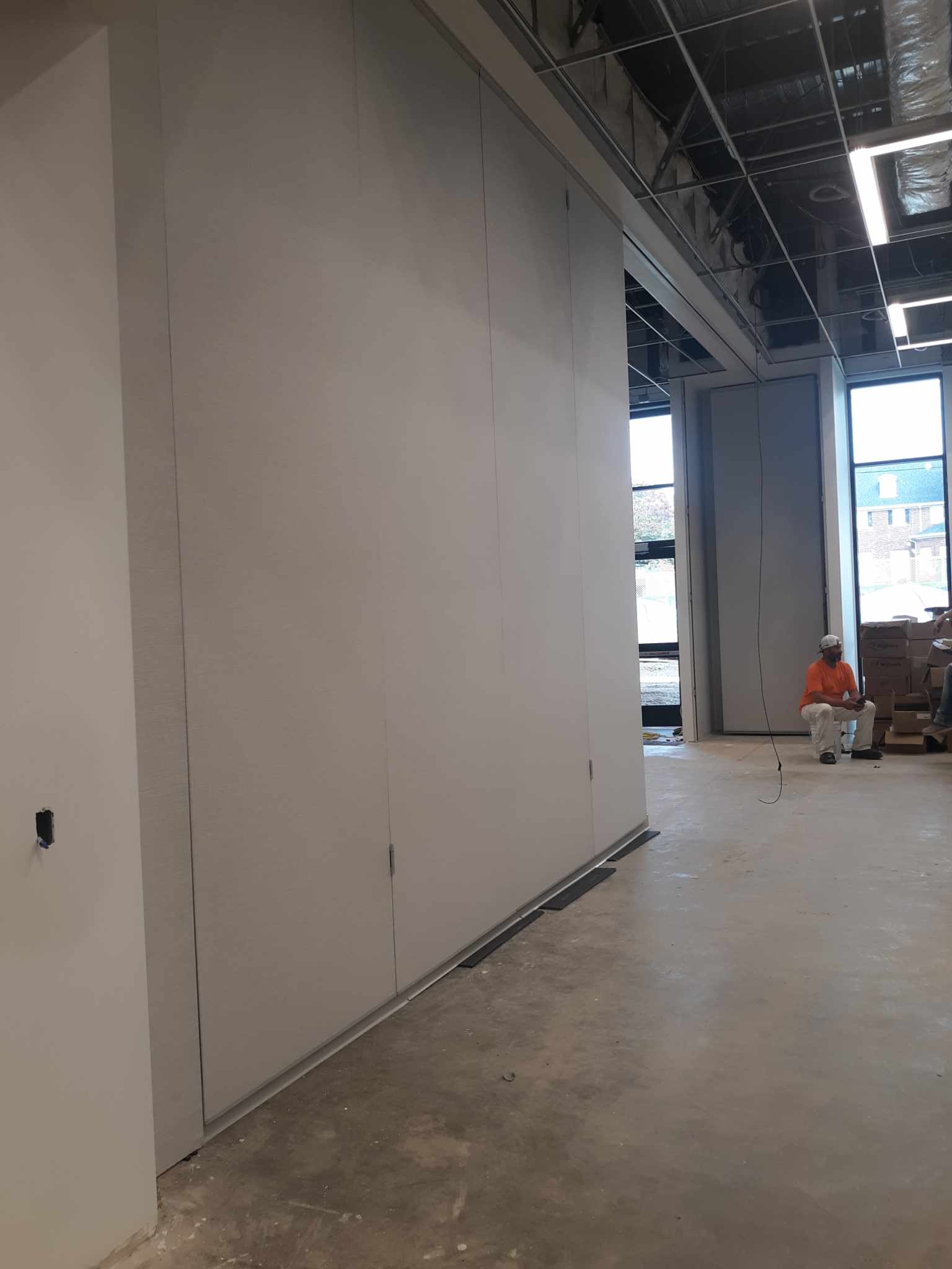Construction crews tests the new community room wall dividers. The image shows the wall between Community room 1 and 2 partially slid out.