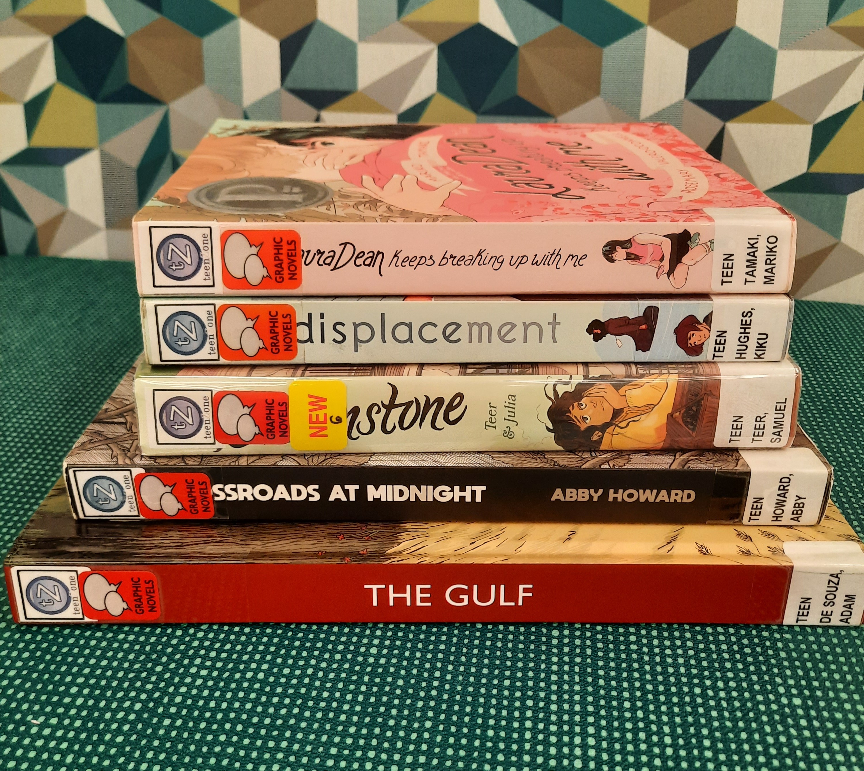 2025 May Book Stack Book Stack showing the following titles: "Laura Dean Keeps Breaking up with me," "Displacement," "Brownstone," "Crossroads at Midnight," and "The Gulf"