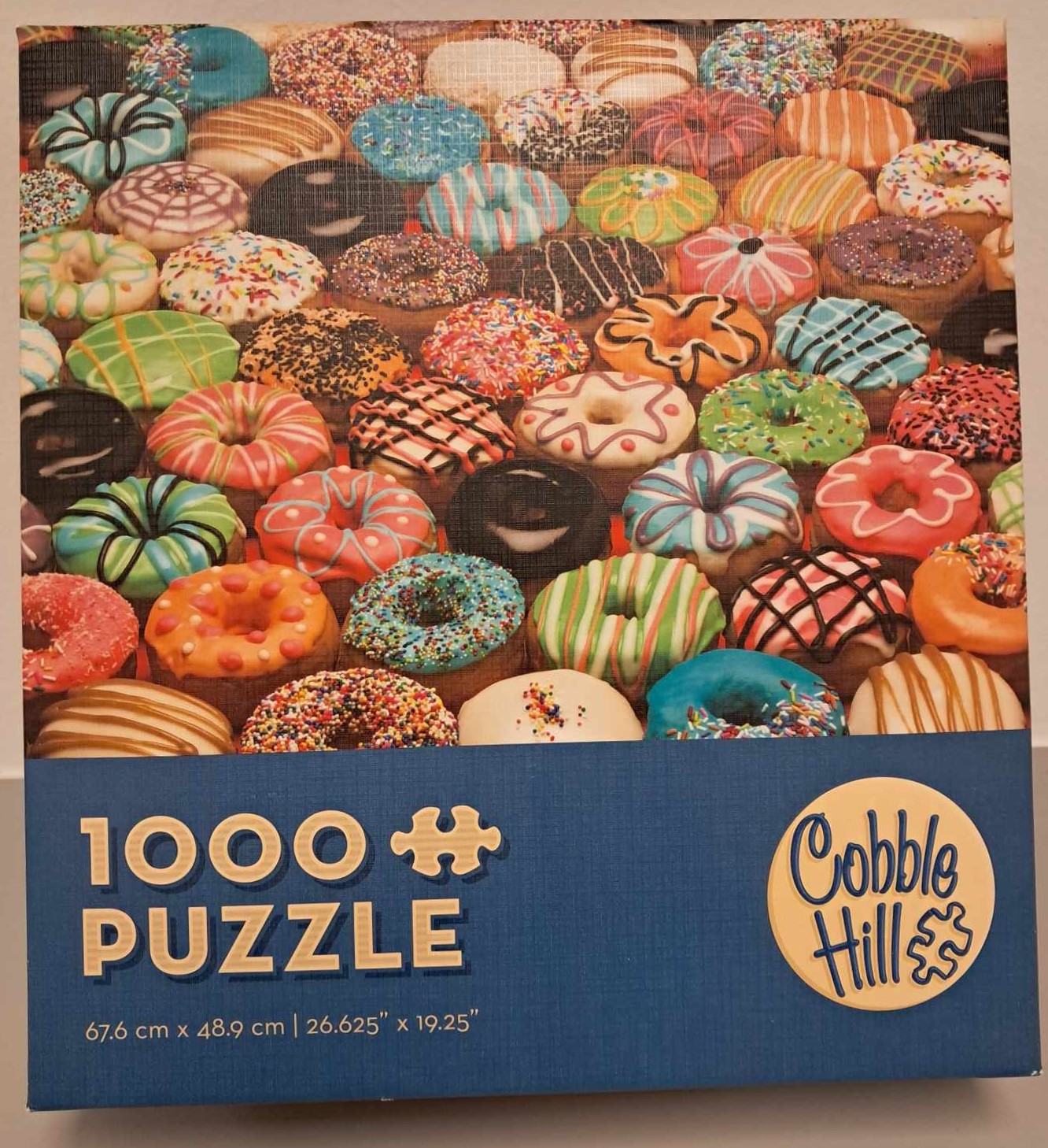 Puzzle cover showing an image of many frosted doughnuts with different colors and sprinkles.