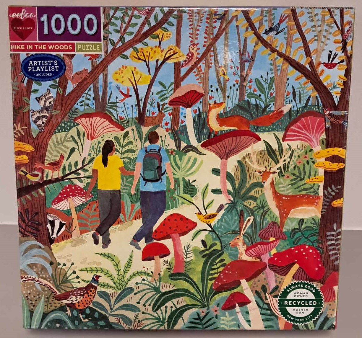Puzzle cover showing an artistic drawing of two people walking along a path with a lot of mushrooms in a forest.