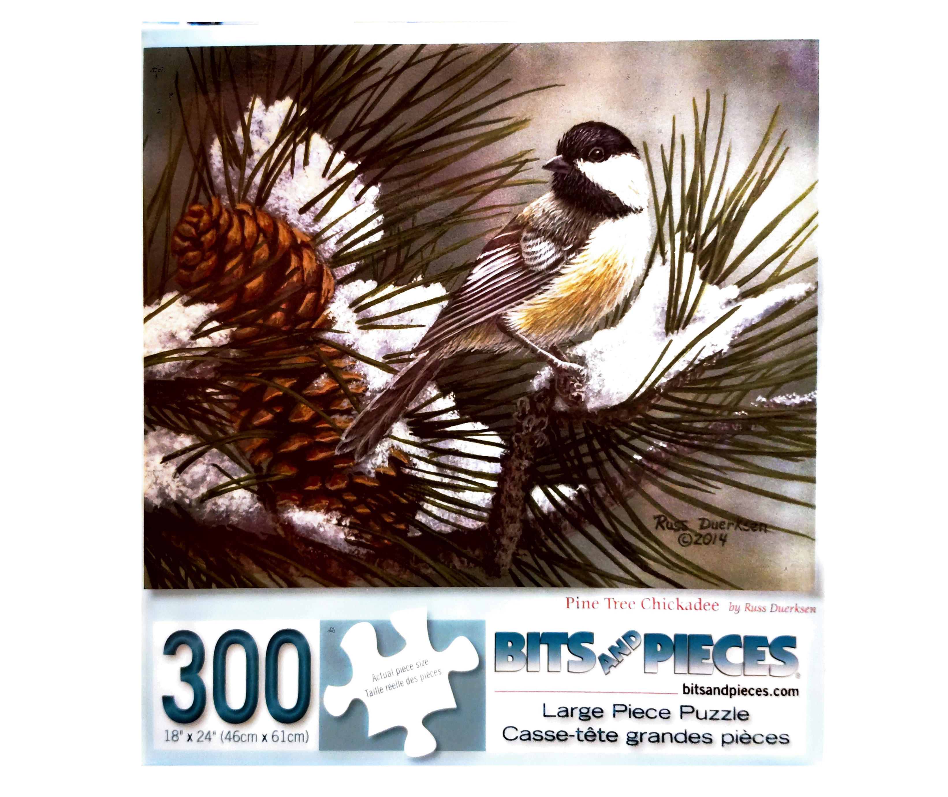 Puzzle cover showing a small bird sitting in a pine tree with snow on the branch and some pine cones.