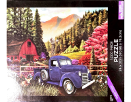 Puzzle cover showing a mountain area with lots of trees and a blue truck parked in front of a red barn.