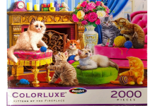 Puzzle cover showing a variety of kittens playing with yarn near an unlit fireplace.