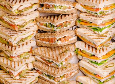 Multiple triangular cut sandwiches stacked together.