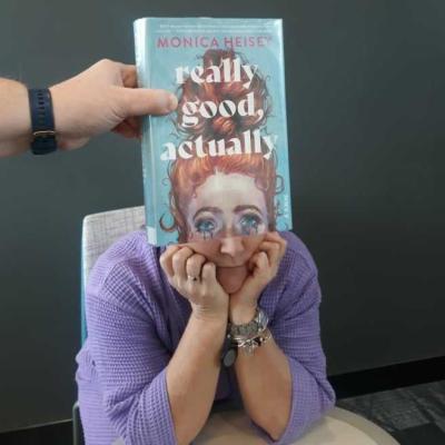 photo of marketing manager, Rhonda Massie, behind a book to make it seem like she's part of the cover